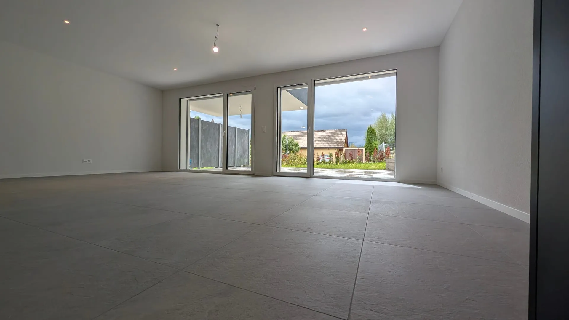 Double accès vitré sur la terrasse — la continuité intérieur-extérieur au quotidien.